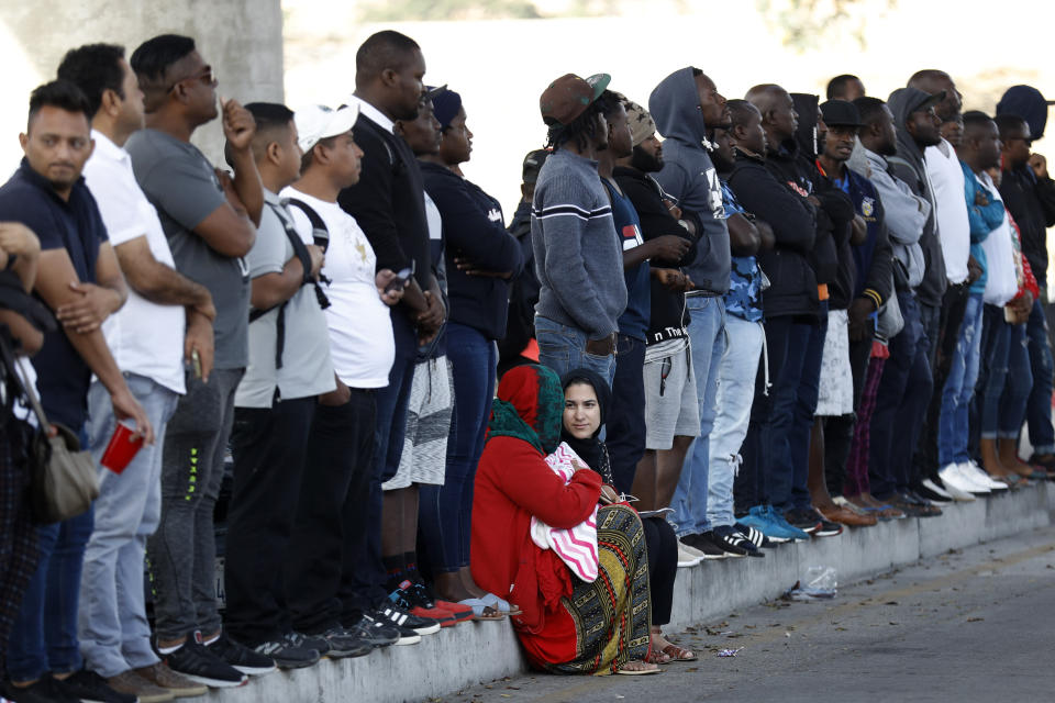 People wait to apply for asylum in the United States along the border, Tuesday, July 16, 2019, in Tijuana, Mexico. Dozens of immigrants lined up Tuesday at a major Mexico border crossing, waiting to learn how the Trump administration's plans to end most asylum protections would affect their hopes of taking refuge in the United States. (AP Photo/Gregory Bull)