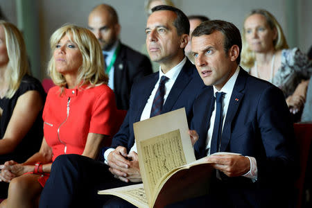 (R-L) French President Emmanuel Macron, Austrian Chancellor Christian Kern and Brigitte Macron react as they listen during a piano masterclass by French pianist Dominique Merlet at the Mozarteum University in Salzburg, Austria, August 23, 2017. REUTERS/Bertrand Guay