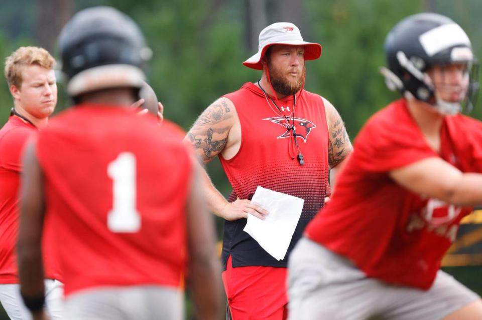 Cardinal Newman Head Coach Cory Helms instructs his team as they practice football on Friday, July 28, 2023.