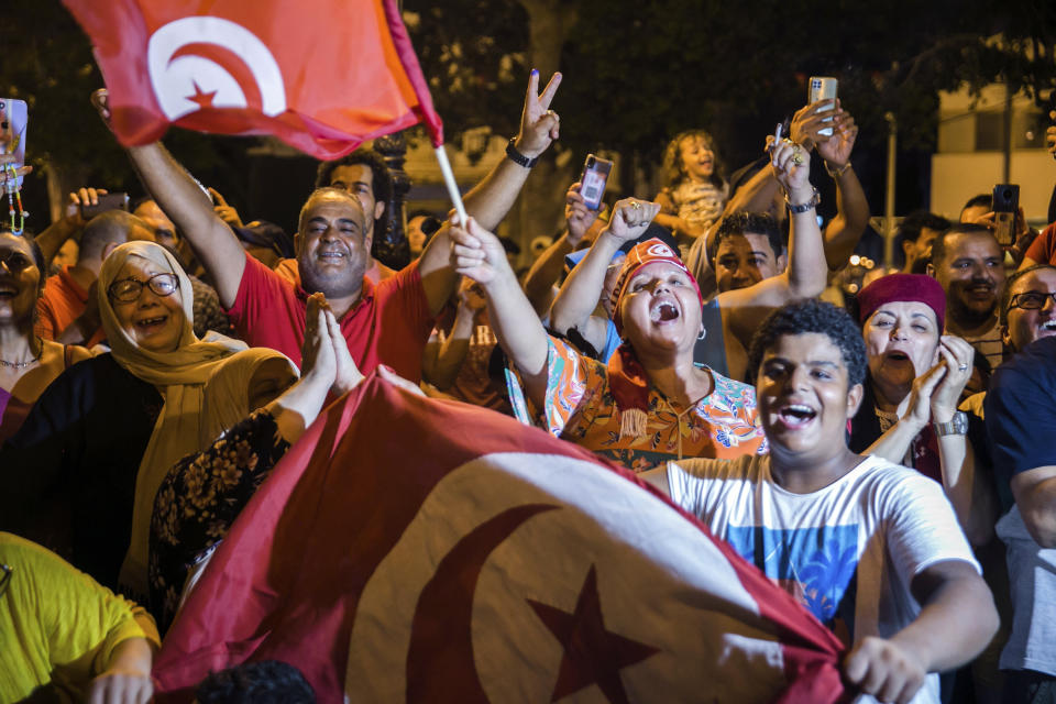 Tunisians celebrate the exit polls indicating a vote in favor of the new Constitution, in Tunis, late Monday, July 25, 2022. Hundreds of supporters of Tunisian President Kais Saied took to the streets to celebrate after the end of voting on a controversial new constitution that critics say could reverse hard-won democratic gains and entrench a presidential power grab. (AP Photo/Riadh Dridi)