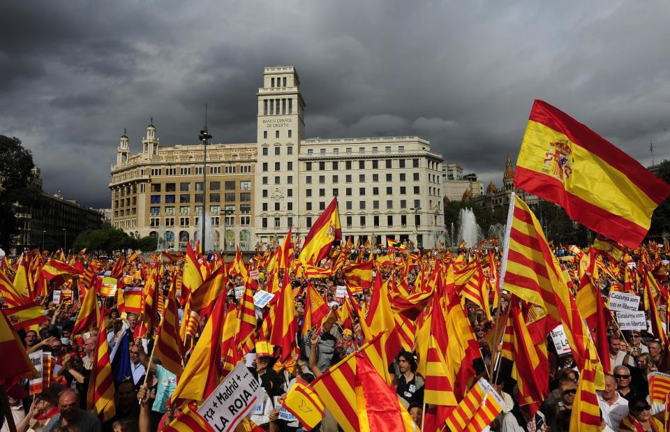 People opposed to the independence of Catalonia hold Catalan and Spanish flags during the holiday known as Dia de la Hispanidad, Spain's National Day in Barcelona, Spain, Friday, Oct. 12, 2012. (AP Photo/Manu Fernandez)