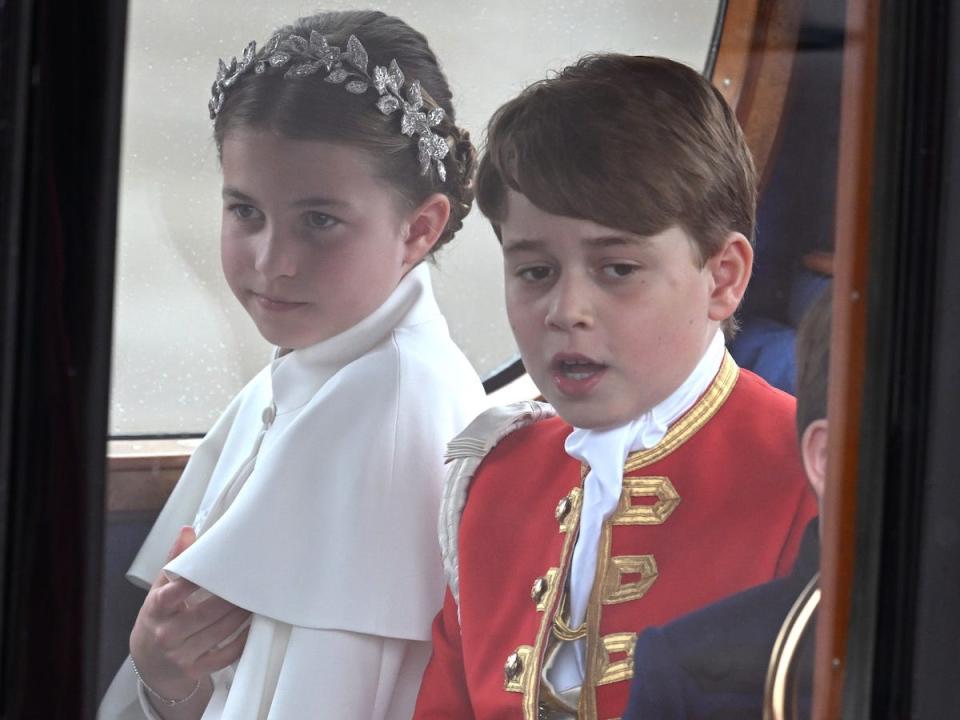 Princess Charlotte and Prince George of Wales depart King Charles' coronation service in a carriage.