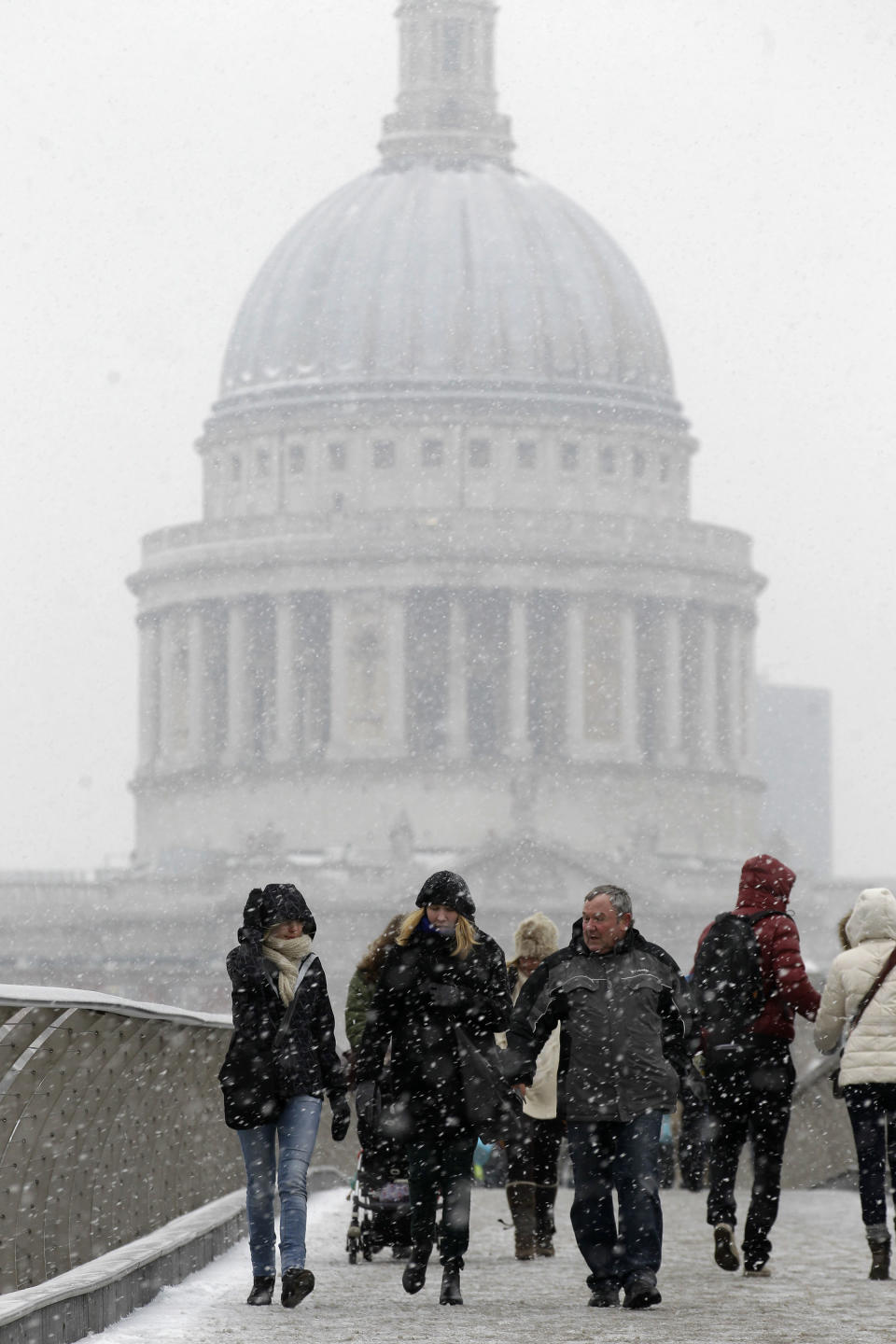 FILE - This Jan. 18, 2013 file photo shows people walking across a snowy Millennium Bridge near St. Paul's Cathedral in London. For visitors on a literary tour of London, the view of the city from the top of the cathedral was shown by David Copperfield to Clara Peggoty in Charles Dickens' "David Copperfield." (AP Photo/Sang Tan, file)