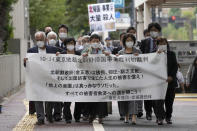 Plaintiffs and their supporters walk toward the Tokyo District Court Thursday, Oct. 14, 2021, in Tokyo. The court is hearing five ethnic Korean residents of Japan and a Japanese national demanding the North Korean government pay compensation over their human rights abuses in that country after joining a resettlement program there that promised a “paradise on Earth,” but without the presence of a defendant - the North’s leader. The banner reads: "Oct. 14 Tokyo District Court the North Korea "Paradise on Earth" campaign first trial. (AP Photo/Eugene Hoshiko)