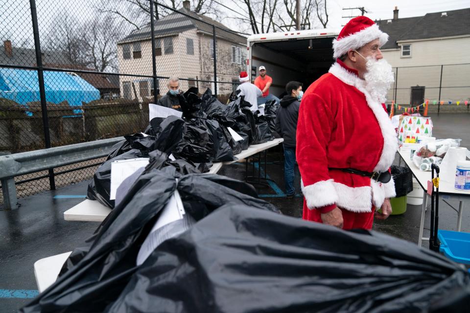 Ray Hillenbrand, 60, of Rochester Hills puts on his best Santa suit before handing out toys to unsuspecting families in Southwest Detroit as part of Jimmy's Kids toy giveaway, a Mitzvah Day event, where volunteers of various faiths come together to help Detroit area nonprofits on Christmas Day. I