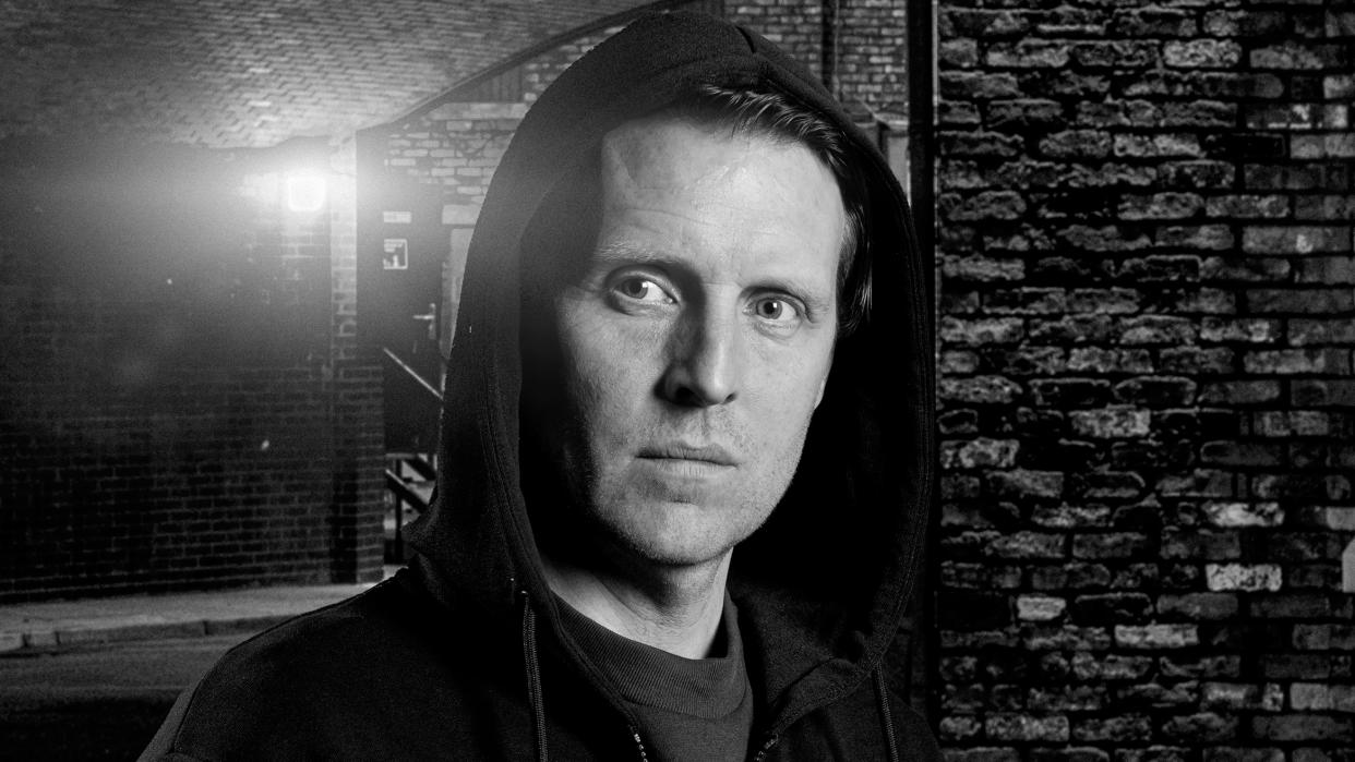  Black and white image of Nathan Curtis (Chris Harper) with his hood up looking menacing in Coronation Street. 