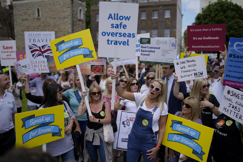 People who work in the UK aviation and travel industry take part in a 'Travel Day of Action' protest across the street from the Houses of Parliament in London, Wednesday, June 23, 2021. The protest on Wednesday was attended by people from across the UK aviation and travel industry calling on the British government to safely reopen international travel for the peak summer season to protect travel jobs and businesses amidst Britain's widely praised rollout of coronavirus vaccines. (AP Photo/Matt Dunham)