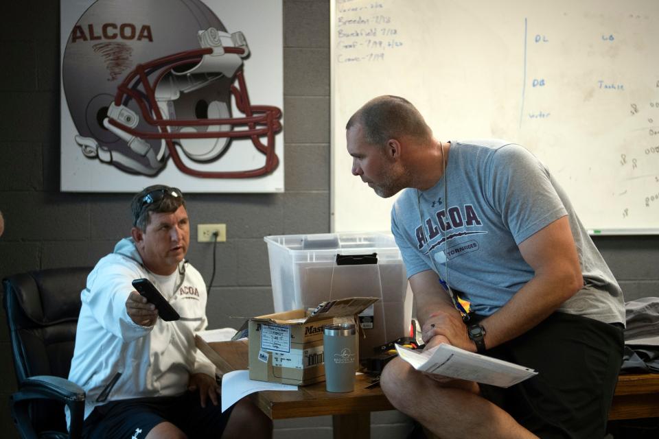 Alcoa High School football coach Brian Nix talks with assistant coach David Sweetland before the start of practice on Monday, July 25, 2022. 