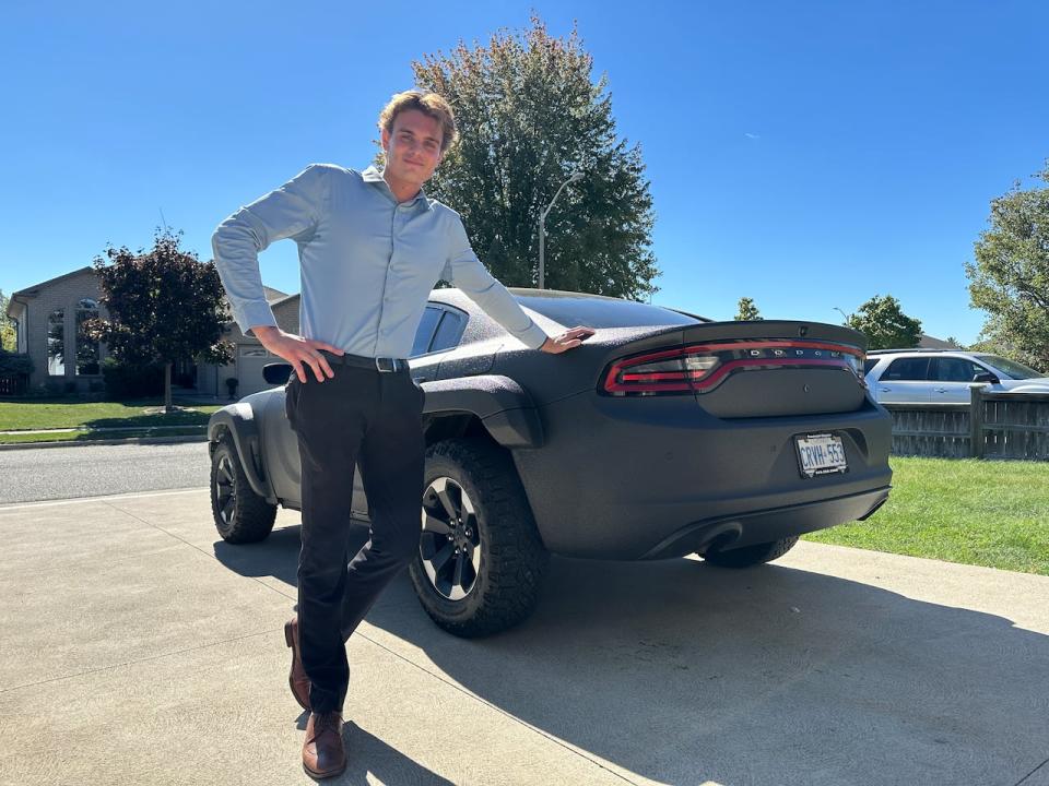 Lucas Kiewitz of Lakeshore next to his personally customized Dodge Charger.