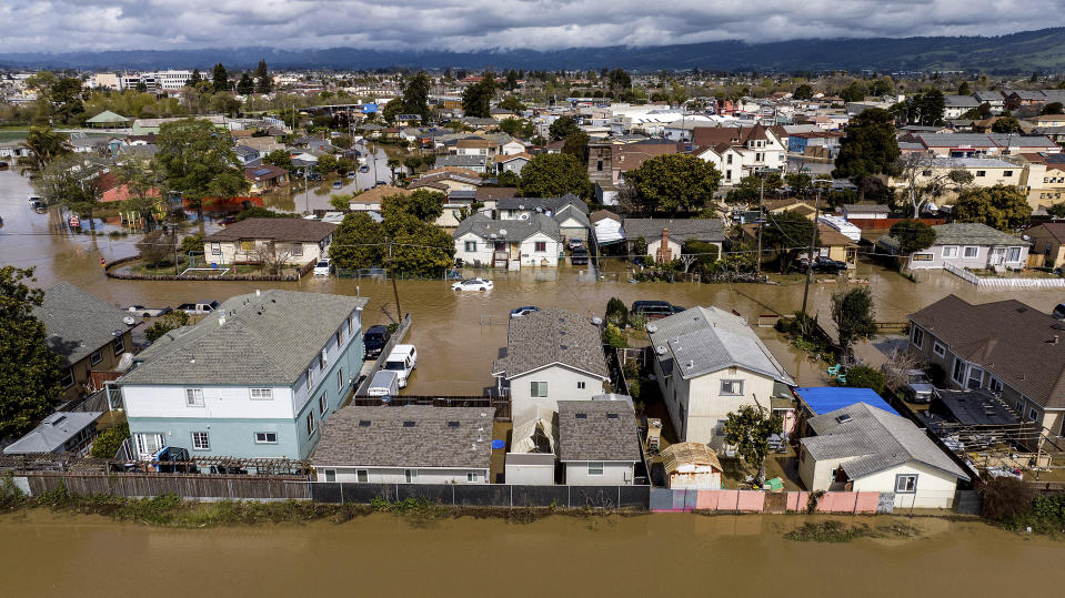 Floodwaters surround homes and vehicles in the community of Pajaro in Monterey County, Calif., on Monday, March 13, 2023. (AP Photo/Noah Berger)