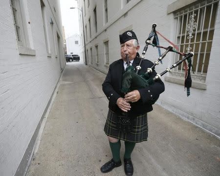 Bagpiper Ben Williams plays music to drown out protestor's (not pictured) chants during Republican U.S. presidential candidate Donald Trump's meeting at Republican National Committee (RNC) headquarters (building surrounding Williams in rear) in Washington, U.S., May 12, 2016. REUTERS/Jim Bourg