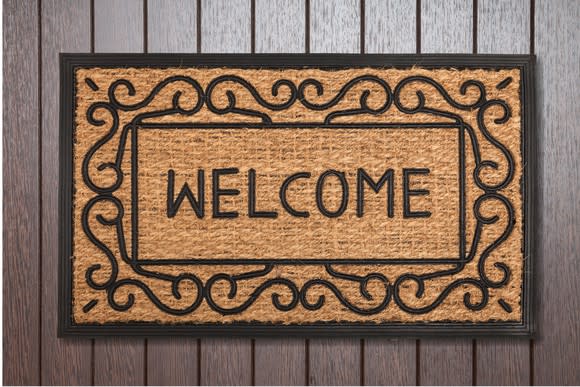 A welcome mat lying on a deck.