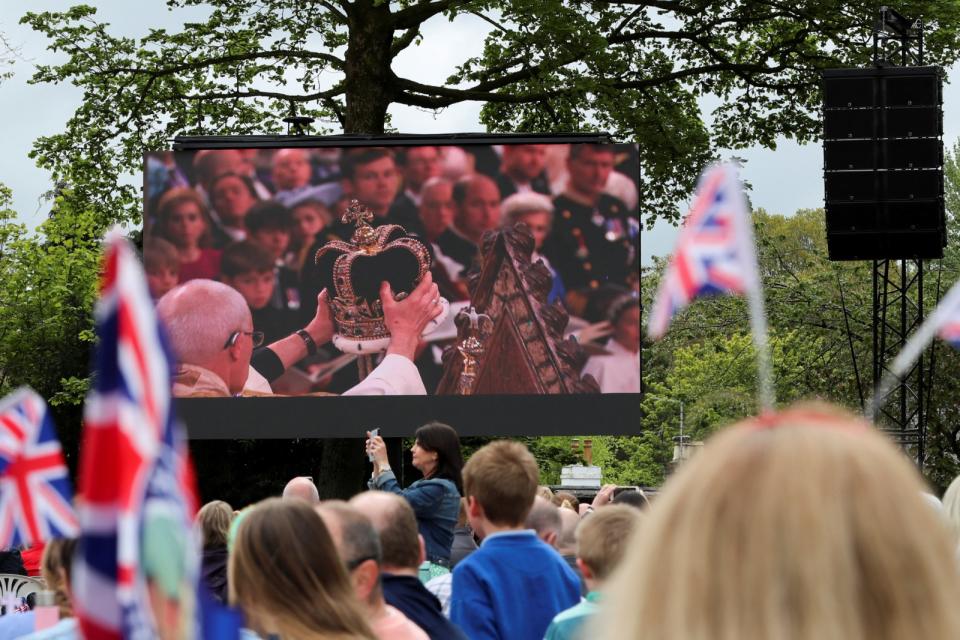 北愛爾蘭民眾透過大螢幕觀看查爾斯三世戴上王冠的一刻。路透社