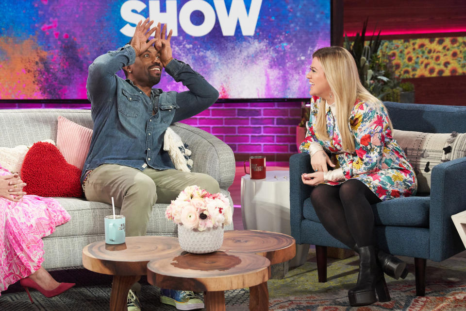 Deon Cole and Kelly Clarkson laugh together on the set of "The Kelly Clarkson Show"