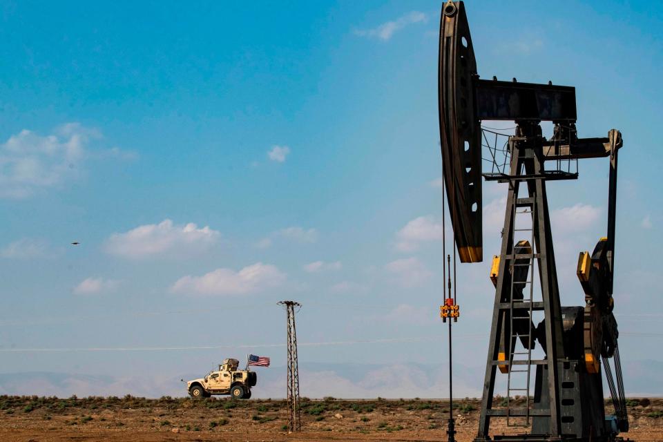 A US military vehicle drives past an oil pump jack in the countryside of Syria's northeastern city of Qamishli on 26 October: AFP/Getty