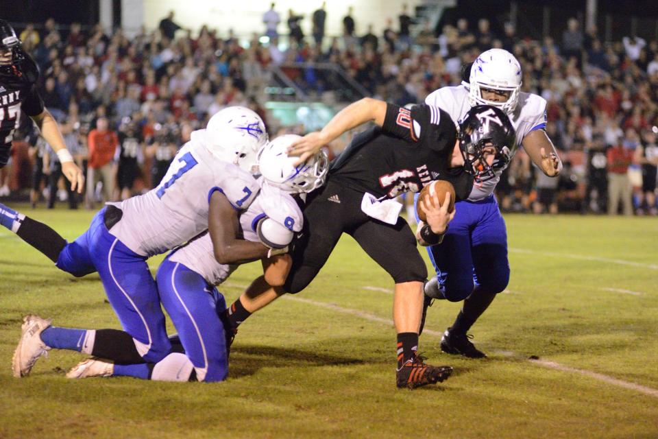 Bishop Kenny quarterback John Wolford gets tackled by Clay's Sean Grayer (7) and Ivan Valenzuela (9) on Nov. 22, 2013. Wolford gained a state-record 773 total yards, but Clay won 74-73 in the highest-scoring playoff in FHSAA history.