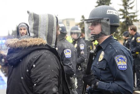 A member of the Black Lives Matter protesters argues with a police officer as they shut down the main road to the Minneapolis St. Paul Airport following a protest at the Mall of America in Bloomington, Minnesota December 23, 2015. REUTERS/Craig Lassig