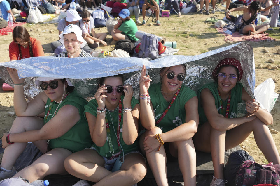 Young pilgrims gather at Parque Tejo in Lisbon where Pope Francis is presiding over a mass celebrating the 37th World Youth Day, Sunday, Aug. 6, 2023. An estimated 1.5 million young people filled the parque on Saturday for Pope Francis' World Youth Day vigil, braving scorching heat to secure a spot for the evening prayer and to camp out overnight for his final farewell Mass on Sunday morning. (AP Photo/Ana Brigida)