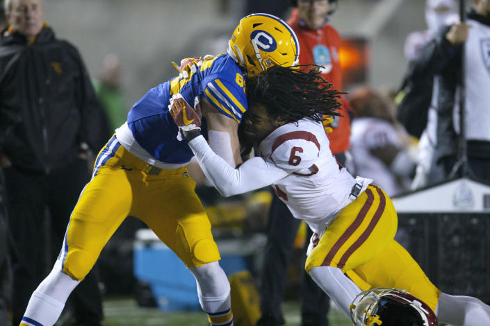 Southern California cornerback Isaac Taylor-Stuart (6) loses his helmet as he forces California tight end Jake Tonges (85) out of bounds after a long pass reception during the second quarter of an NCAA college football game, Saturday, Dec. 4, 2021, in Berkeley, Calif. (AP Photo/D. Ross Cameron)