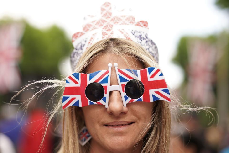 A member of the public wearing Union Jack glasses on the Mall (PA)
