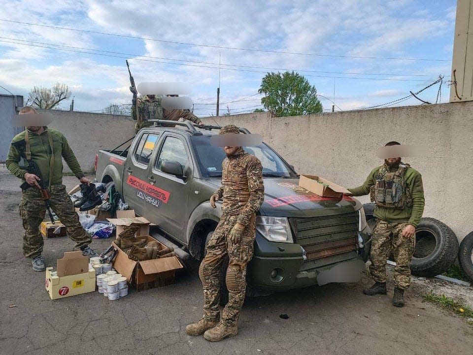 Anonymous Ukrainian soldiers with a Cars4Ukraine vehicle