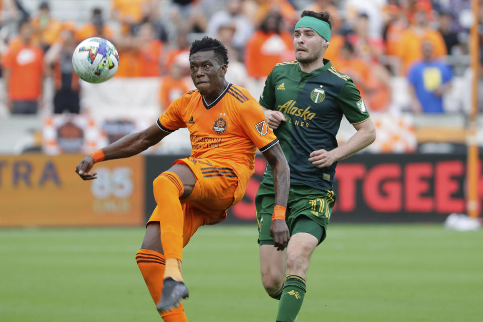 Houston Dynamo defender Teenage Hadebe, left, brings down the ball in front of Portland Timbers forward Jarosław Niezgoda (11) during the second half of an MLS soccer match Saturday, April 16, 2022, in Houston. (AP Photo/Michael Wyke)