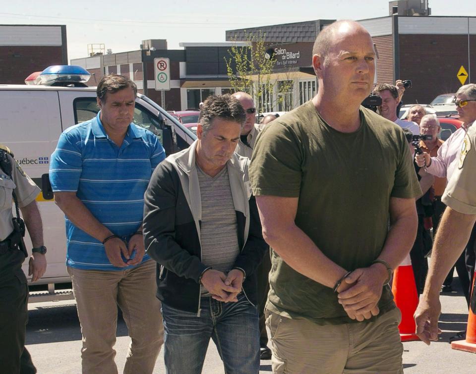 Three former Montreal Maine & Atlantic Railway Ltd. employees are escorted by police to appear in court in Lac-Mégantic, Que., in May 2014. All three were later acquitted. THE CANADIAN PRESS/Ryan Remiorz