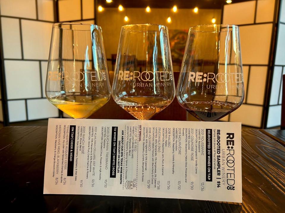 three wine glasses and a paper menu in front of them at re:rooted in san antonio