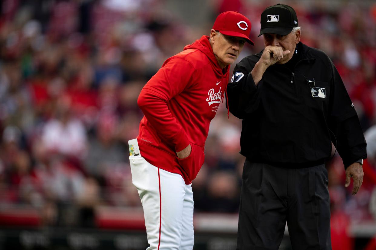 Reds manager David Bell speaks with umpire Larry Vanover in the first inning of Saturday's game against the Angels.