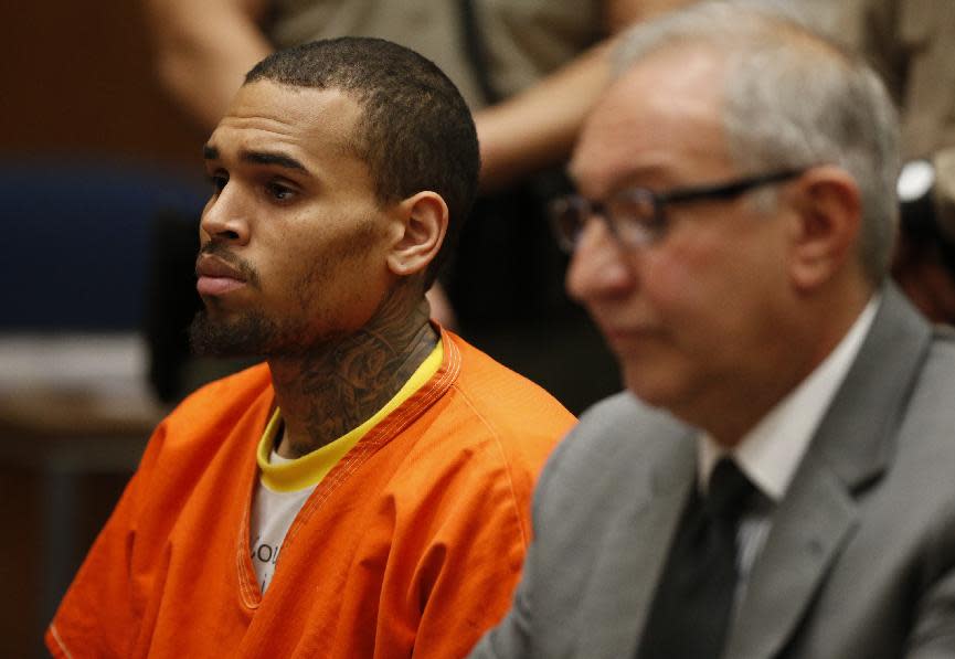 R&B singer Chris Brown, left, appears in Los Angeles Superior Court with his attorney Mark Geragos, on Monday, March 17, 2014. Brown will spend another month in jail after a judge said Monday he was told the singer made troubling comments in rehab about being good at using guns and knives. The singer was arrested on Friday, March 14, 2014, after he was dismissed from a Malibu facility where he was receiving treatment for anger management, substance abuse and issues related to bipolar disorder. (AP Photo/Lucy Nicholson, Pool)