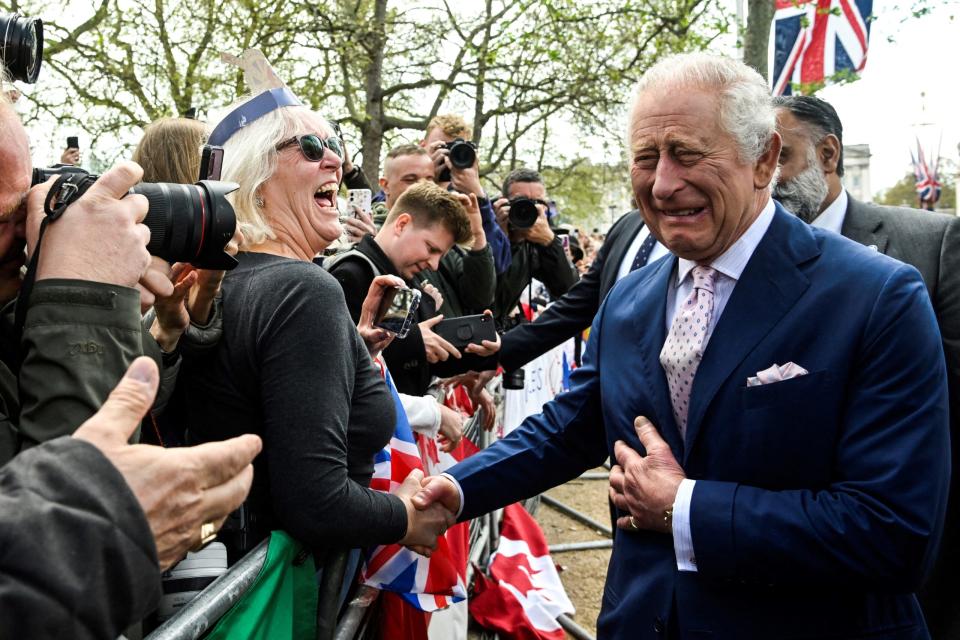 El rey Carlos III saluda a algunas personas afuera del Palacio de Buckingham un día antes de su coronación. Foto: AFP