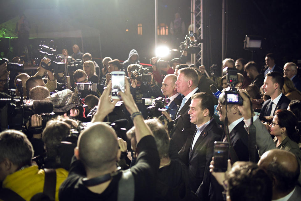 Romanian President Klaus Iohannis is surrounded by media after exit polls results indicate him as the leader of the presidential race, with up to 40 percent of the votes in Bucharest, Romania, Sunday, Nov. 10, 2019. An election runoff will take place on Nov. 24. (AP Photo/Andreea Alexandru)