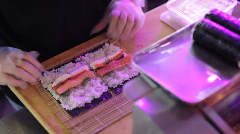 Sushi being rolled on bamboo