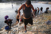Un migrante hondureño discapacitado al que le falta una pierna regresa a la orilla guatemalteca del río Suchiate, en la frontera con México en Tecun Uman, Guatemala, el lunes 20 de enero de 2020. (AP Foto/Moisés Castillo)