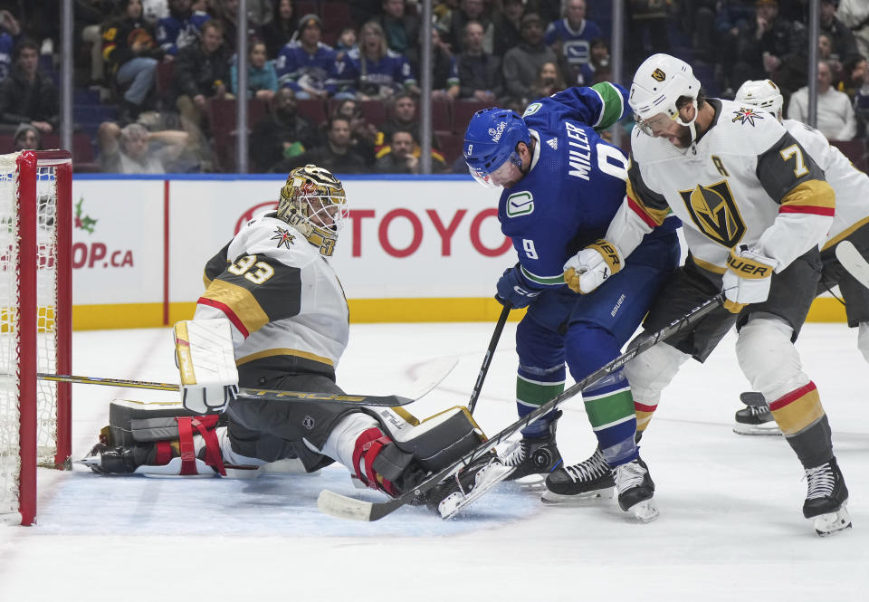 Vegas Golden Knights goalie Adin Hill (33) stops Vancouver Canucks' J.T. Miller (9) as Golden Knights' Alex Pietrangelo (7) defends during the first period of an NHL hockey game Thursday, Nov 30, 2023, in Vancouver, British Columbia. (Darryl Dyck/The Canadian Press via AP)