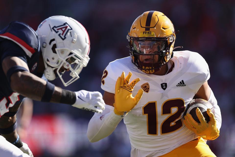 Tight end Jalin Conyers #12 of the Arizona State Sun Devils runs with the football after a reception against safety Christian Young #5 of the Arizona Wildcats during the first half of the NCAAF game at Arizona Stadium on Nov. 25, 2022, in Tucson, Arizona. This year's game is the 96th annual Territorial Cup match between Arizona's rival schools.