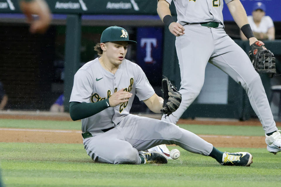 Oakland Athletics second base Zack Gelof (20) fails to make catch on a bloop hit by Texas Rangers' Jared Walsh (not shown) during the seventh inning of a baseball game Thursday, April 11, 2024, in Arlington, Texas. (AP Photo/Michael Ainsworth)