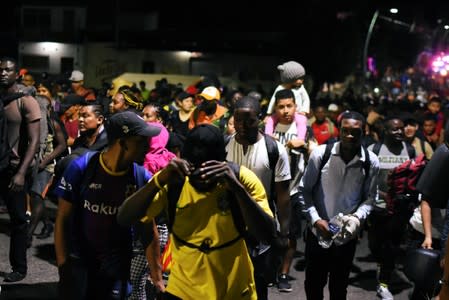 Migrants walk along a street in a caravan towards the United States, in Tapachula