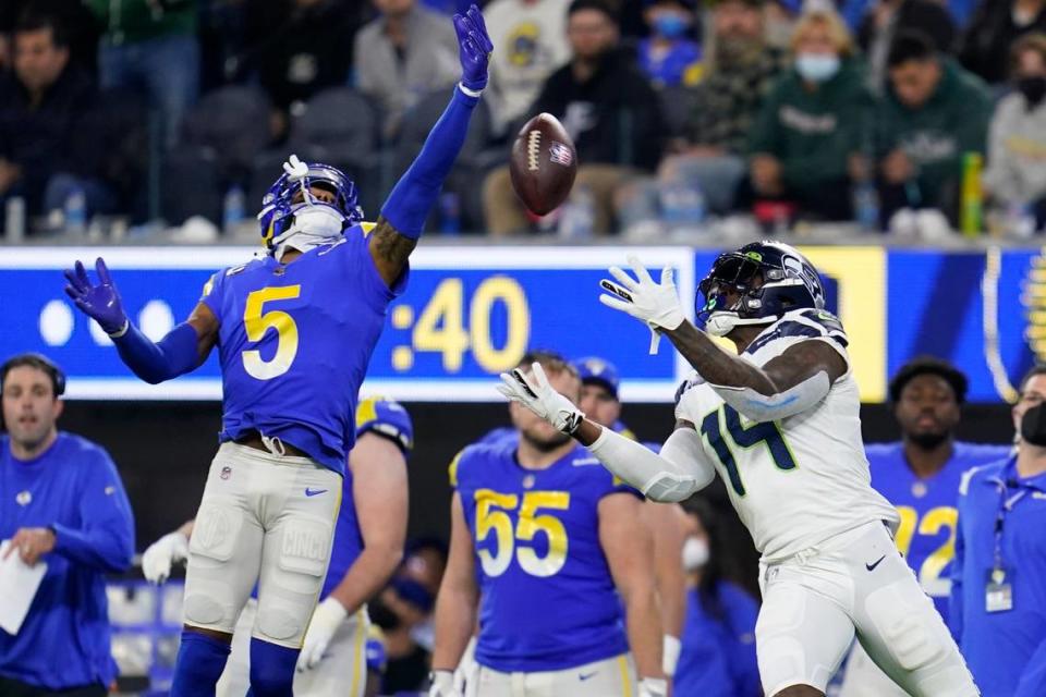 Los Angeles Rams cornerback Jalen Ramsey (5) breaks up a pass intended for Seattle Seahawks wide receiver DK Metcalf (14) during the second half of an NFL football game Tuesday, Dec. 21, 2021, in Inglewood, Calif. (AP Photo/Ashley Landis)