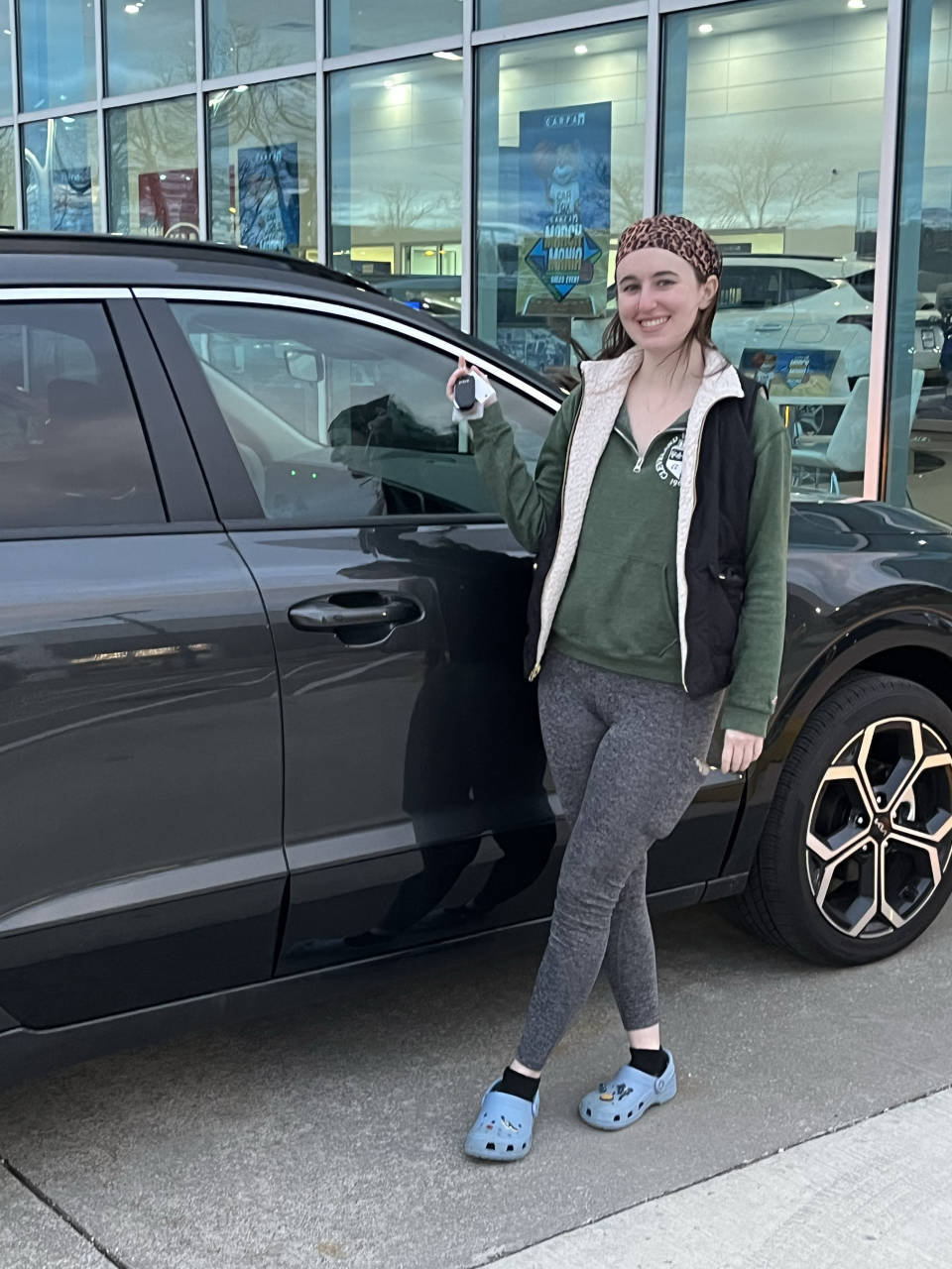 Megan Keleman poses in front of her new car in Crocs, her favorite everyday shoes.