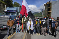 Indigenous Mayor Jose Tax Sapon, at center wrapped in a white flag, and neighbors pose for a portrait as they block the Inter American Highway in Totonicapan, Guatemala, after Indigenous leaders here called for a nationwide strike to pressure Guatemalan President Alejandro Giammattei to resign, Thursday, July 29, 2021. The protest comes in response to the firing of Special Prosecutor Against Impunity Juan Francisco Sandoval by Attorney General Consuelo Porras. (AP Photo/Moises Castillo)