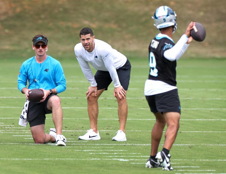 Carolina Panthers head coach Dave Canales, center, watches as quarterback Bryce Young, right, drops back to pass during the team’s voluntary minicamp on Wednesday, April 24, 2024.