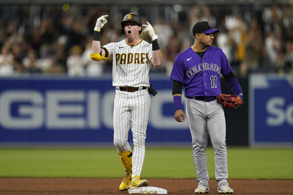 San Diego Padres' Jake Cronenworth, left, gestures after a two-run double, next to Colorado Rockies shortstop Jose Iglesias during the fourth inning of a baseball game Friday, June 10, 2022, in San Diego. (AP Photo/Gregory Bull)