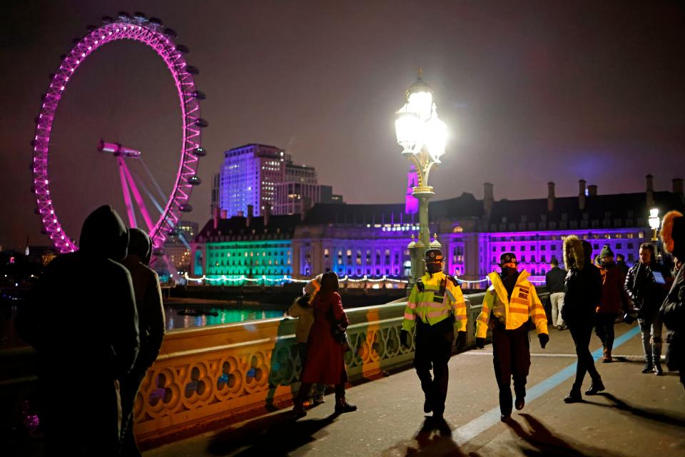 Police officers disperse people on Westminster Bridge in a near-deserted London on New Year's Eve, December 31, 2020, as authorities hope the message to stay at home is obeyed.