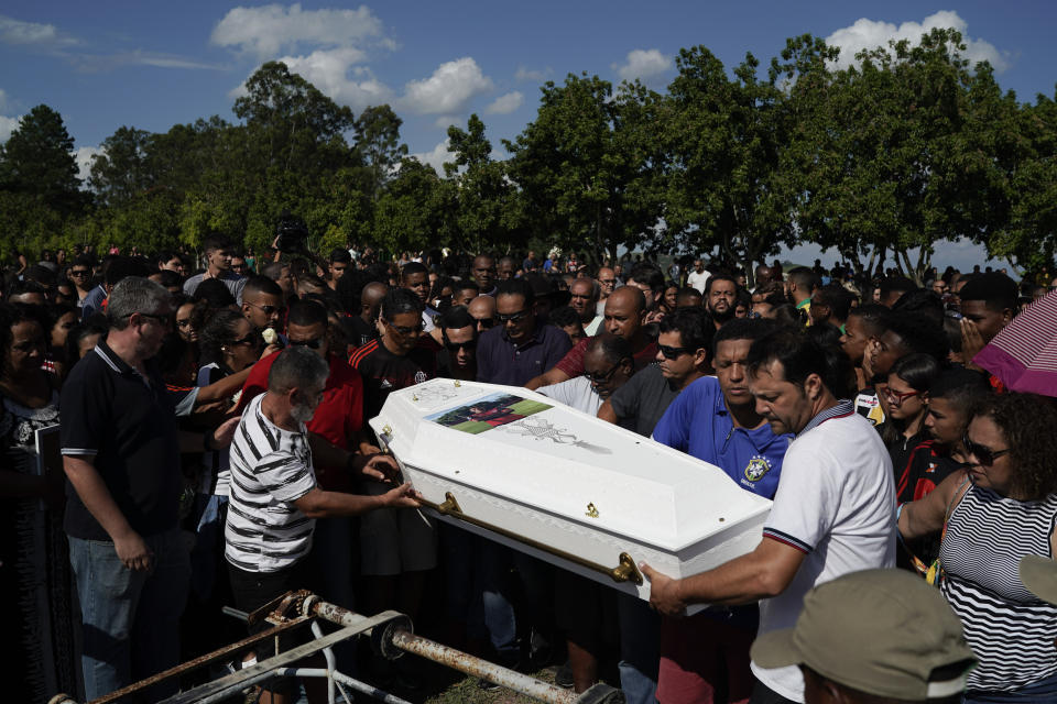 Friends and relatives carry the coffin containing the remains of the young soccer player Arthur Vinicius, one of the victims of a fire at a Brazilian soccer academy, during his burial in Volta Redonda, Brazil, Saturday, Feb. 9, 2019. A fire early Friday swept through the sleeping quarters of an academy for Brazil's popular professional soccer club Flamengo, killing several and injuring others, most likely teenage players, authorities said. (AP Photo/Leo Correa)