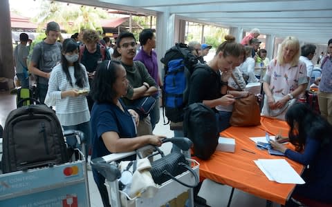 Tourists try to obtain flight information following the closure of Ngurah Rai airport - Credit: Reuters