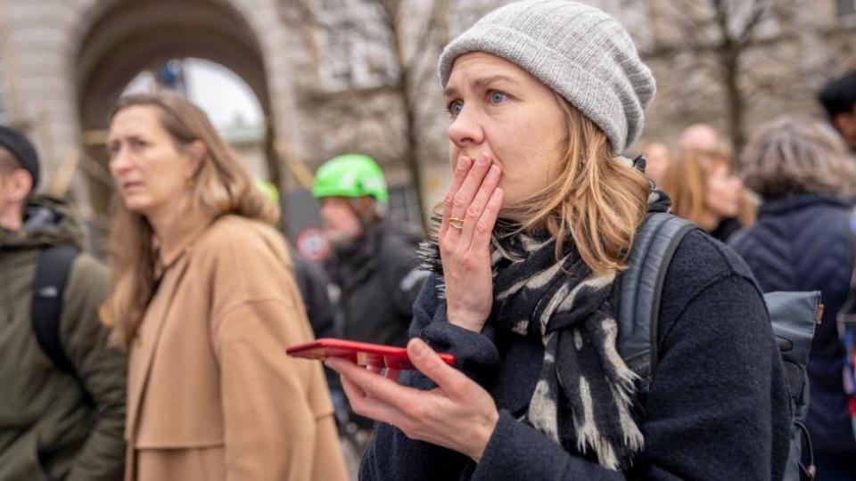 People react as the Stock Exchange building burns in central Copenhagen, Denmark on April 16, 2024