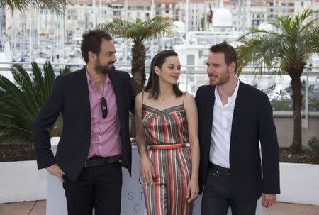 (L-R) Director Justin Kurzel, cast members Marion Cotillard and Michael Fassbender pose during a photocall for the film "Macbeth" in competition at the 68th Cannes Film Festival in Cannes, southern France, May 23, 2015. REUTERS/Yves Herman