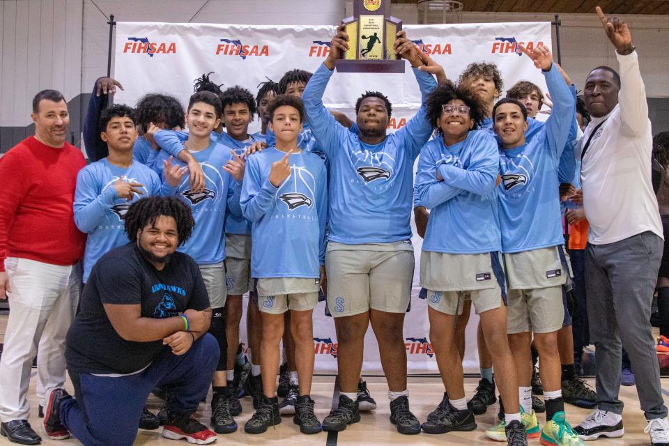 The Jordan Christian Prep boys basketball team holds the trophy after winning the FIHSAA state title on Friday afternoon at Webber International.