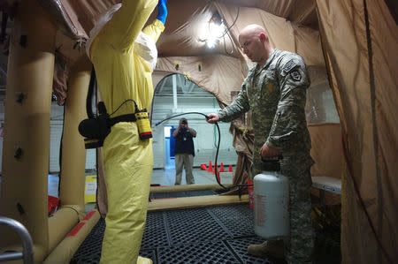 A U.S. Army soldier from the 101st Airborne Division (Air Assault), who are earmarked for the fight against Ebola, goes through decontamination process training before their deployment to West Africa, at Fort Campbell, Kentucky October 9, 2014. REUTERS/Harrison McClary